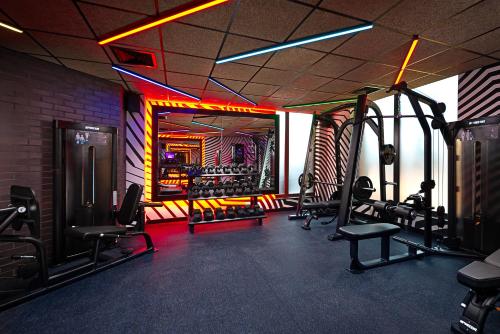 都柏林NYX Hotel Dublin Portobello的健身房,配有有氧器材和椅子