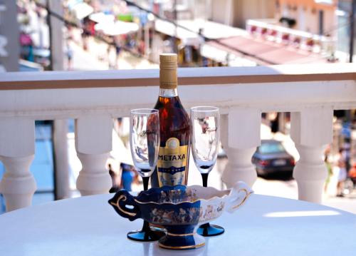 帕拉利亚卡泰里尼斯奥斯卡酒店的桌子上放有一瓶葡萄酒和两杯酒