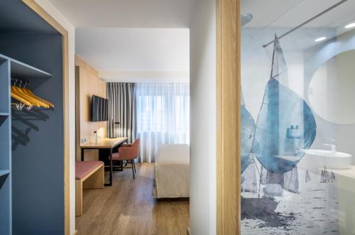 阿利坎特Occidental Alicante的客房设有带一张床和一张书桌的卧室。