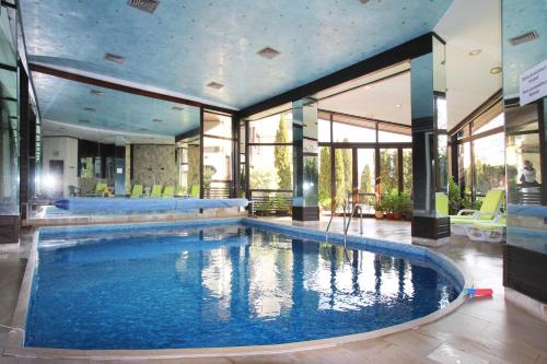 班斯科Alpine Lodge Bansko Apartments的一座大型游泳池,位于一座带窗户的建筑内