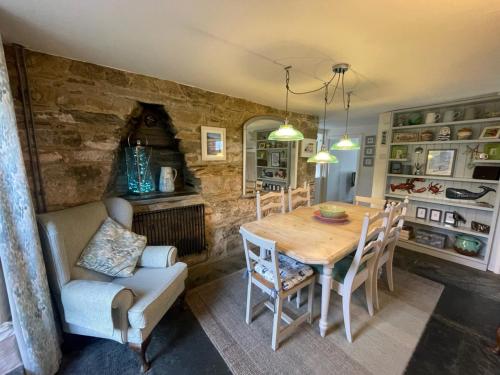圣提斯Sandown 4 bedroom house St Teath的一间带木桌和椅子的用餐室