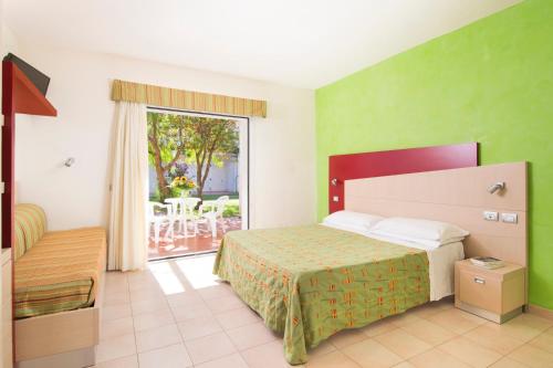 玛丽纳锡巴里Sibari Green Resort的酒店客房设有一张床和一个阳台。