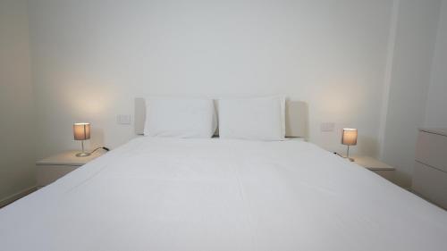 帕多瓦Palazzo Gilberto的一间卧室配有一张带两盏灯的大型白色床。