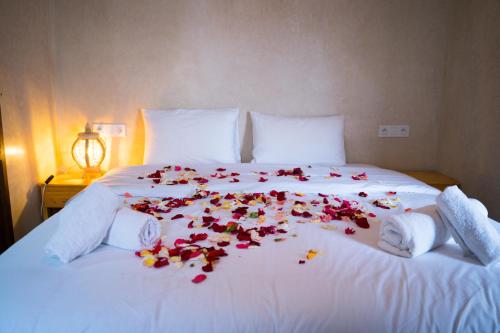 马拉喀什RIAD LAICHI的一张带鲜花的白色床