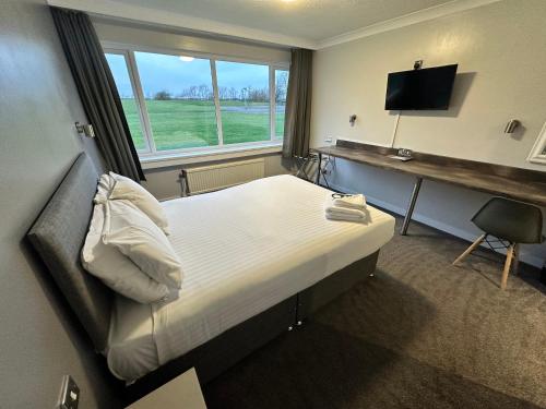 米德尔斯伯勒米德尔斯堡运动住宿酒店的一间卧室配有一张床、一张书桌和一台电视