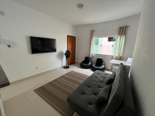 卡皮托利乌Apartamento Aconchegante的带沙发和平面电视的客厅