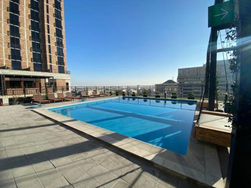 蒙特雷New luxury and comfort apartment, fully furnished in Monterrey Centro. (Includes: Pool, Parking lot, A.C., WiFi, Gym)的大楼顶部的大型游泳池