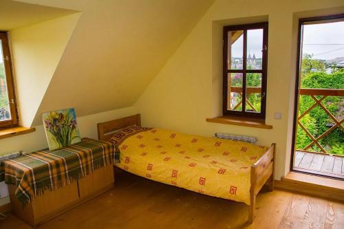 卡缅涅茨-波多利斯基Tisnyi 7 Guest House的一间卧室设有一张床和两个窗户。