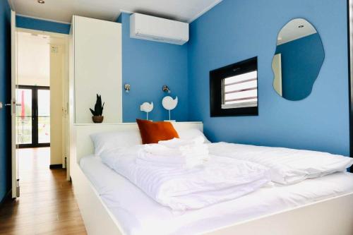 赫克斯特Hausboot CALIENE - LP9的卧室配有白色床和蓝色墙壁