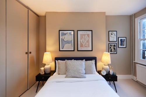 伦敦The Elmington Estate Place - Elegant 1BDR Flat的一间卧室配有一张大床和两盏灯