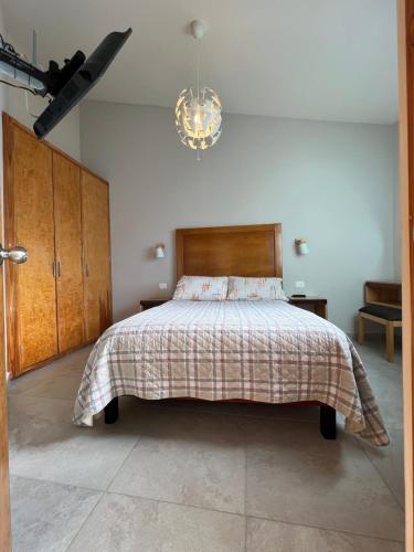 帕丘卡德索托Privada 400的一间卧室配有一张床和一个吊灯
