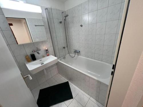 萨梅丹Chesa Fischer Wohnung Palü ÖV-Inklusive的浴室配有白色浴缸、水槽和淋浴。