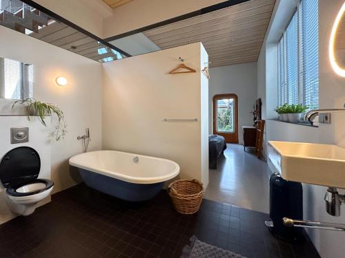 斯哈亨VillaNobel的带浴缸、卫生间和盥洗盆的浴室