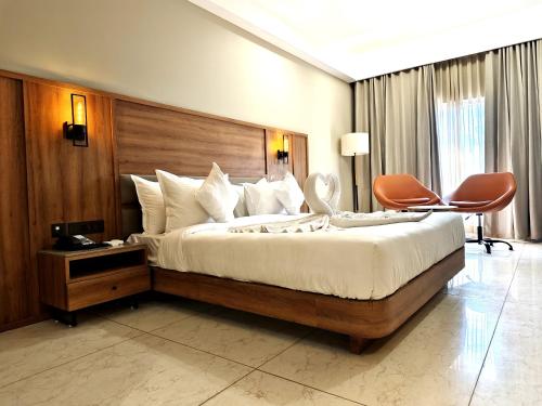 贾姆讷格尔The Sky Imperial Hotel Kailash的一间卧室配有一张大床和木制床头板