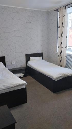 乌斯季卡缅诺戈尔斯克Ак-Тай Гостиный Двор的客房设有两张床和窗户。