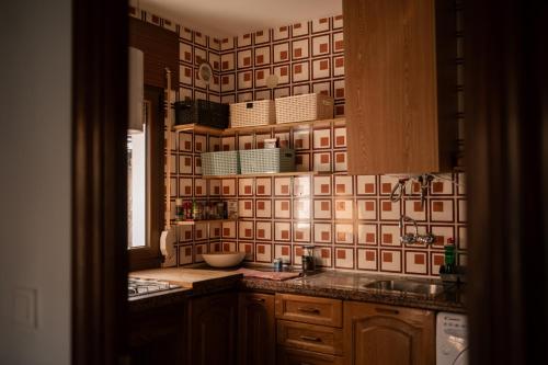 阿尔巴拉辛Casa rural Hitohouse Bed&Climb的厨房设有水槽和瓷砖墙