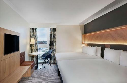 克罗伊登伦敦克罗伊登希尔顿酒店的酒店客房,配有床和电视