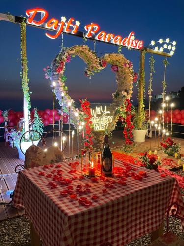 地拉那DAJTI PARADISE RESORT的一张桌子,上面放着一瓶葡萄酒和两颗心