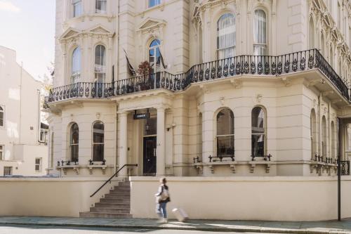伦敦Sonder Kensington Gardens的站在建筑物前走的女人