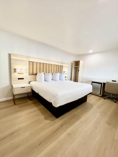 旧金山弗朗西斯科湾旅馆的卧室配有一张白色大床和一张书桌