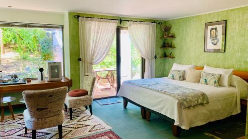 CuracavíKURALEMU Casa de Campo的一间卧室配有一张床、一张书桌和一个窗户。