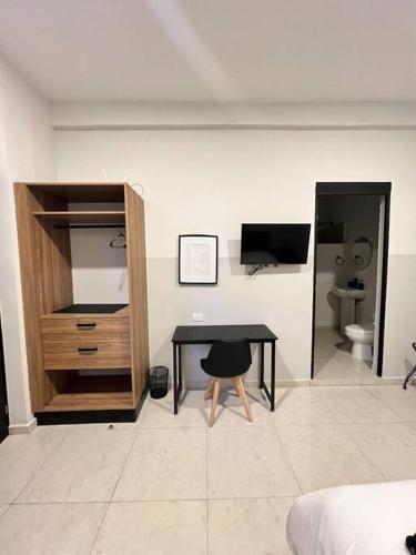 比亚埃尔莫萨Lofts的一间带书桌和电视的房间以及一间卧室