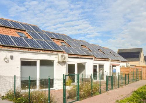 布列登Salty - Vakantiehuisje op de grens van Bredene-De Haan的屋顶上设有太阳能电池板的房子