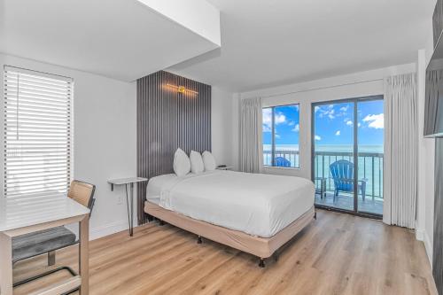 默特尔比奇Grande Beach Resort的一间白色卧室,配有床和阳台
