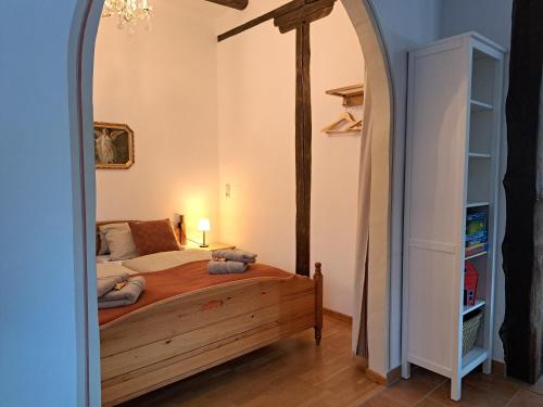 SuderburgFerienwohnung im Heidjerhaus的一间卧室设有一张床和一个拱门