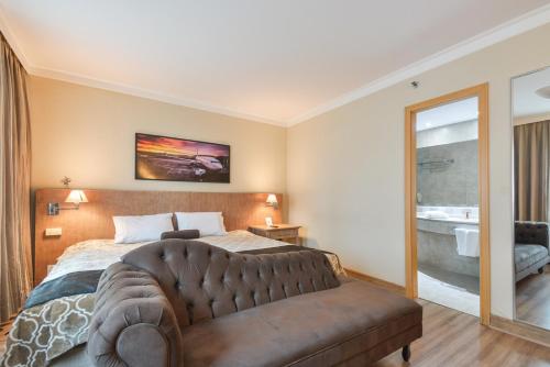 圣保罗Premium room Berrini的一间卧室配有一张大床和一张沙发