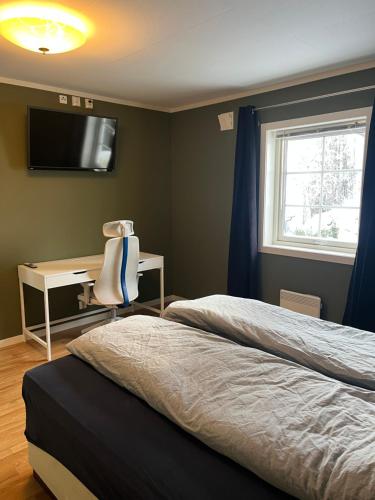 ÅmotStue, soverom og bad的一间卧室配有两张床、一张桌子和一台电视。