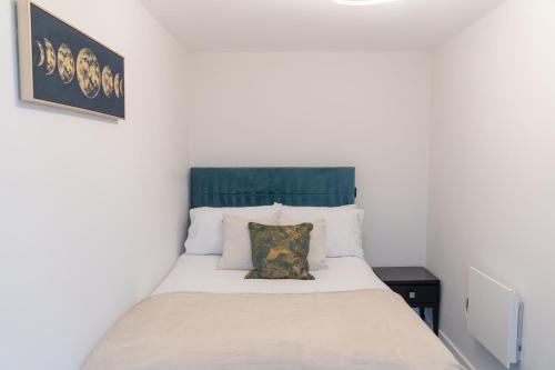 伯明翰Apex Lofts Suite - Modern 2 bed with rooftop terrace的一间卧室配有一张白色床和绿色床头板