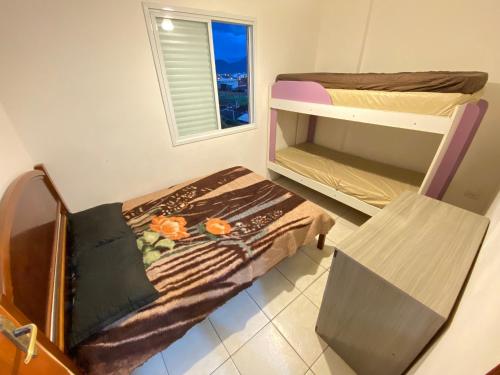 索莱马Pé na Areia Praia do Caiçara的小房间设有双层床和椅子