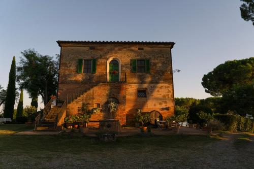 PozzuoloVilla Cozzano的一座带绿门和窗户的大型砖砌建筑