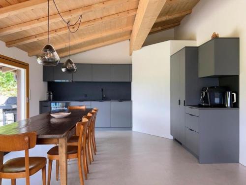 莱克斯Casa Campanula - No 1 Ferienhaus in Laax的厨房配有木桌和椅子