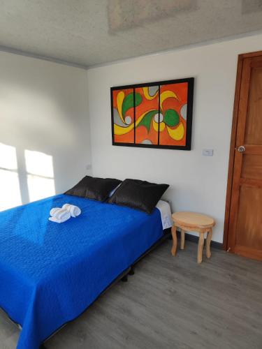 圣罗莎德卡瓦尔Apartamento vía a termales的一间卧室配有一张蓝色的床和一张桌子