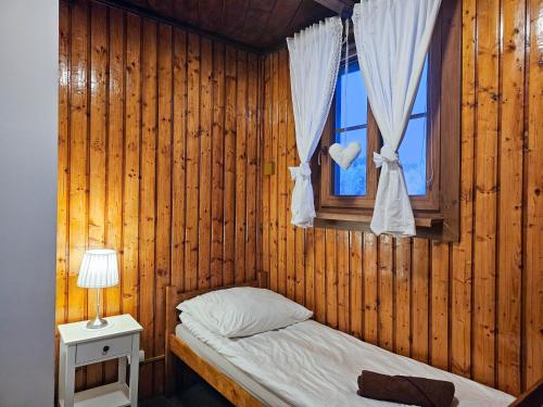 乌斯特龙SCHRONISKO GOŚCINIEC RÓWNICA的一间小卧室,配有床和窗户