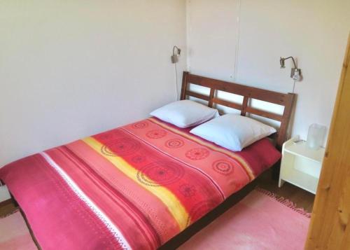 WaldPilgerwohnung - b48531的一间卧室配有一张带红色和黄色毯子的床