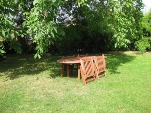 林多夫Gemütliches Ferienhaus in Lindow Mark mit Garten und Grill - b48500的草地上的野餐桌和长凳