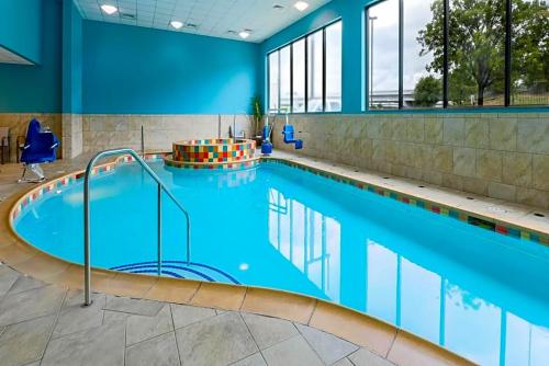 沃思堡Holiday Inn Express & Suites Downtown的大楼内一个蓝色的大型游泳池