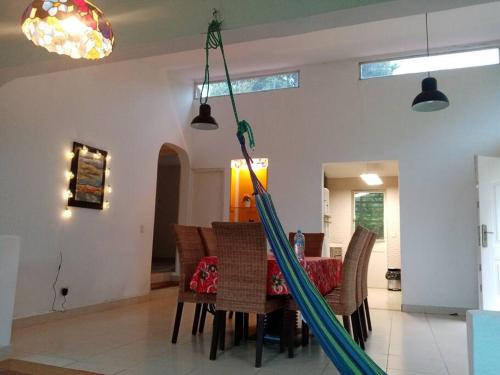 塞罗阿苏尔Cabaña Holly Water的用餐室设有吊床,天花板上挂着吊床