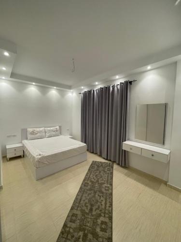 赫尔格达Apartments in Florenza Khamsin的白色卧室配有床和镜子