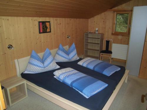 哈斯利伯格Ferienwohnung Nägeliplatten - b48644的一间卧室配有一张带蓝色和白色枕头的床
