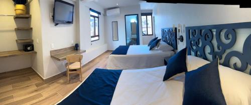 塔斯科·德·阿拉尔孔Centrico House的一间卧室配有两张床和电视。