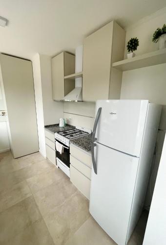 埃斯佩兰萨TERRA - Departamento 1的白色的厨房配有冰箱和炉灶。