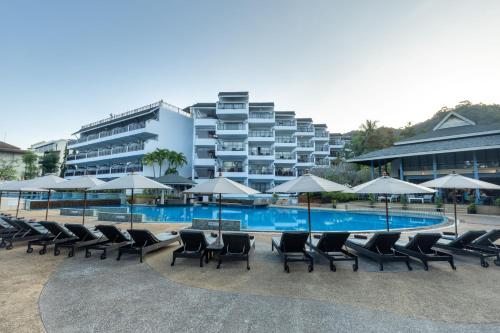 奥南海滩Krabi La Playa Resort - SHA Plus的一组椅子和遮阳伞,位于游泳池旁