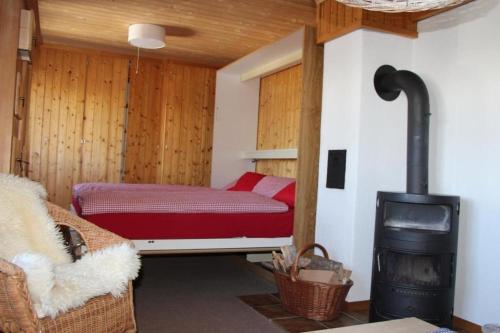 阿克斯普Chalet Huusli - b48809的客房设有一张床和一个燃木炉