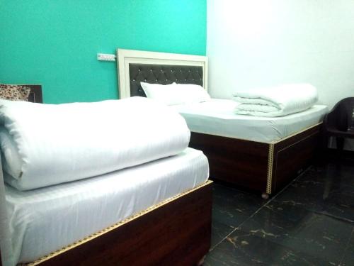 哈里瓦Haridwar and kedarnath dharmshala的蓝色墙壁客房中的两张单人床