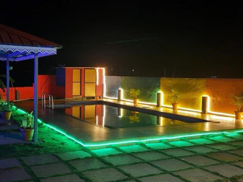 阿利鲍格PALM VILLA & Cottage的游泳池在晚上点亮,灯光照亮
