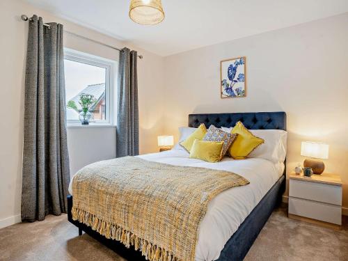 3 bed property in Gower South Wales 91727的一间卧室配有一张带黄色枕头的床和一扇窗户